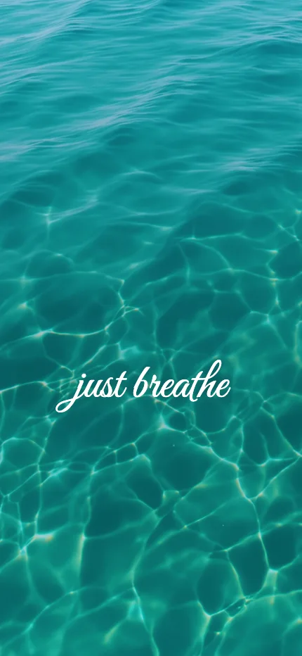Calm iPhone lock screen wallpaper with the words “just breathe” over a ocean photo